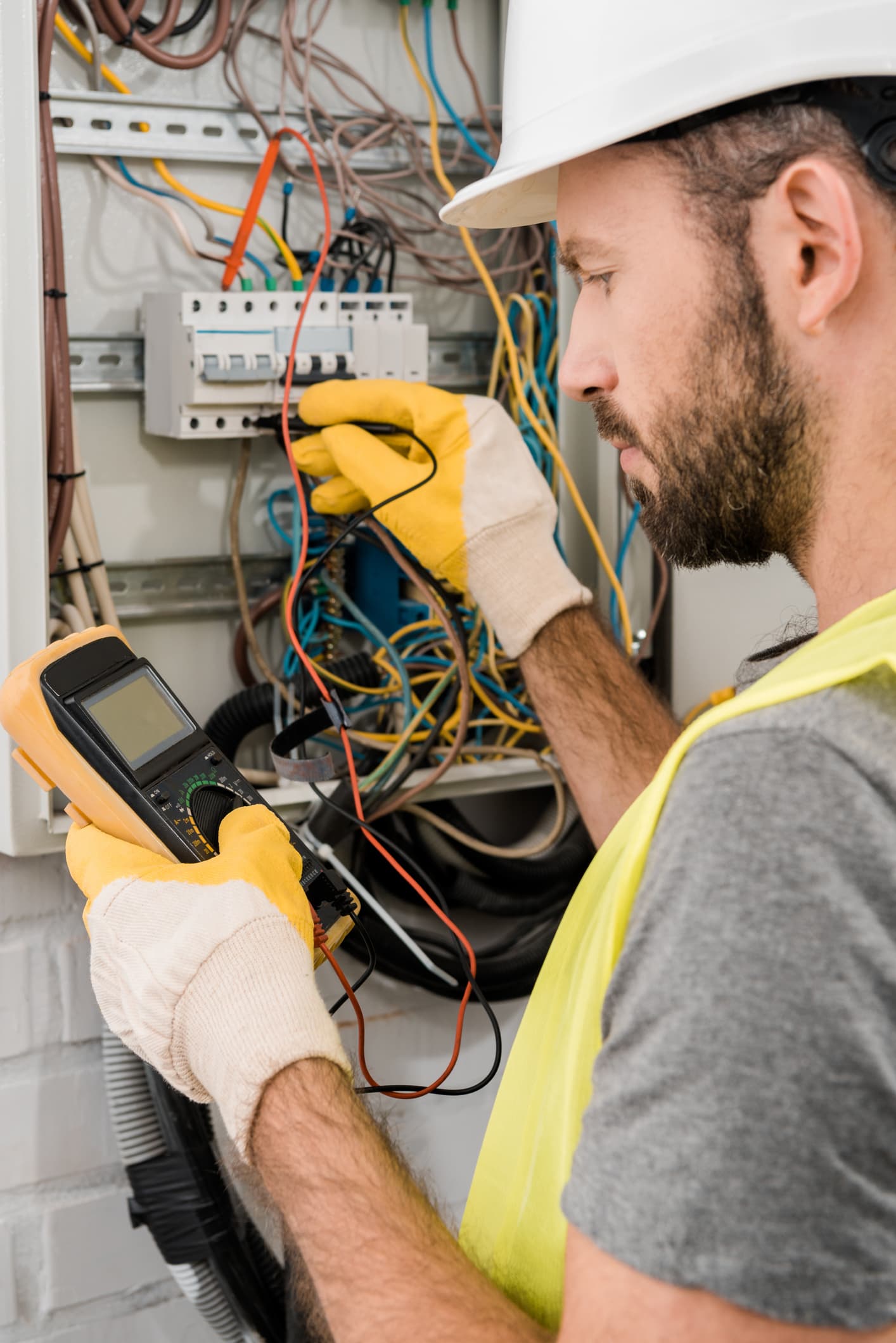 Two electricians looking inside an electrical box